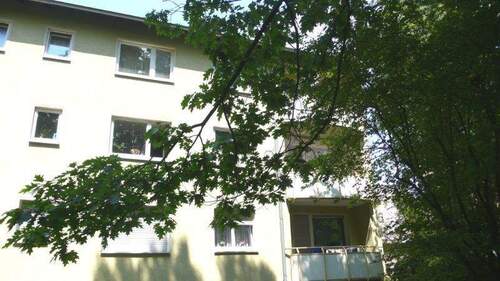 Außenansicht des Wohngebäudes, inklusive Balkon und begrüntem Umfeld - Helle 3,5-Zimmer-Wohnung mit Balkon in Hanau Großauheim