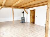 Wohnzimmer mit Kaminofen & Holzbalkendecke, Blick Richtung Flurbereich - untere Wohnebene - 6 Zimmer Etagenwohnung zur Miete in Riesa