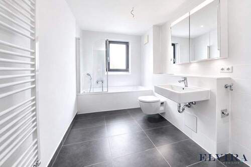 Badezimmer mit Badewanne und Waschmaschinenanschluss - 