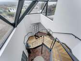 Treppenhaus mit markanter Glasfassade und Ausblick - 