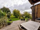 Sonnige Holzterrasse mit Blick ins Grüne - 