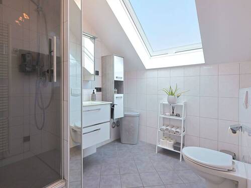 Zeitloses Tageslichtbad mit moderner Ausstattung und Duschkabine - 