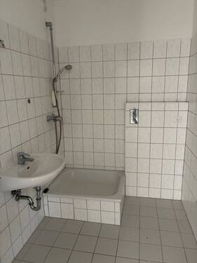 Beispielhaftes Bild des Bads mit Dusche, weiße Sanitärobjekte, weiße Wand- und Bodenfliesen - Etagenwohnung mit 44,10 m&sup2; in Darmstadt zur Miete