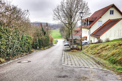 Anwohnerstraße mit Blick auf das Grundstück - 
