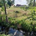 Blick von Wassergraben auf das Grundstück - 