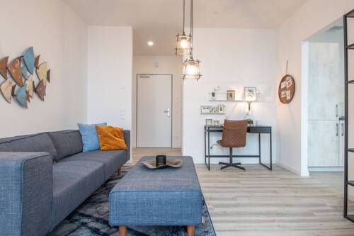 Beispiel eines offenen Wohnzimmer mit weißen Wänden, weißer Decke und holzfarbenen Vinylboden - 