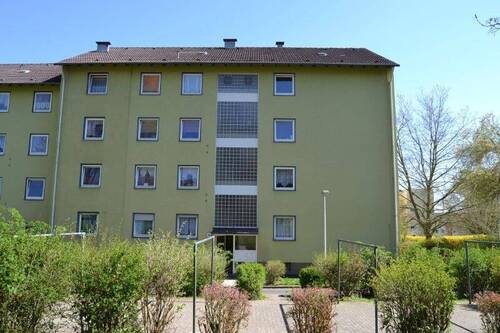 Dachsbergstraße 26: Außenansicht auf den barrierefreien Eingangsbereich eines mehrgeschossigen Wohngebäudes mit heller Fassade. - 4 Zimmer Etagenwohnung zur Miete in Baunatal