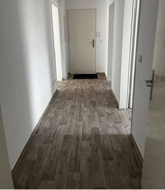 Flur mit hellen Wänden und hellem Bodenbelag in Holzoptik.JPG - 4 Zimmer Etagenwohnung in Baunatal