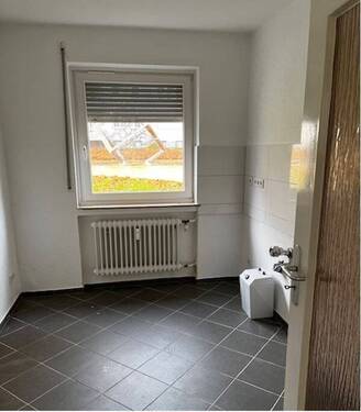 Arbeitsküche mit Fenster, weißer Fliesenspiegel, helle Wände und graue Bodenfliesen.JPG - Etagenwohnung mit 89,80 m² in Baunatal zur Miete