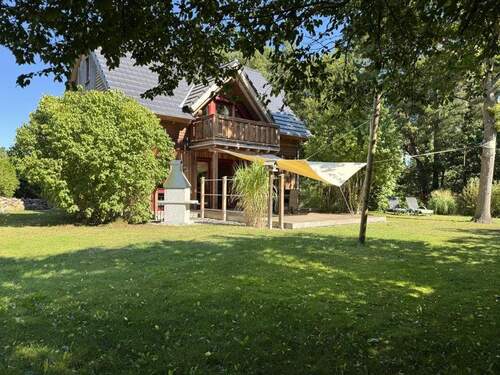 Hausansicht - Natürlich gebautes Haus mit Luftwärmepumpe und Holzschuppen