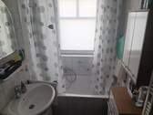 Badezimmer mit Wanne und Fenster - 
