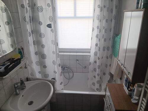 Badezimmer mit Wanne und Fenster - 