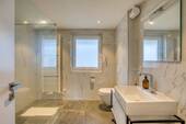 Hochwertiges Badezimmer mit deckenhoch gefliesten Wänden und bodenebener Dusche - 
