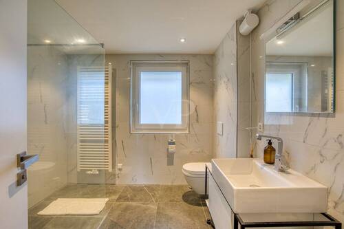 Hochwertiges Badezimmer mit deckenhoch gefliesten Wänden und bodenebener Dusche - 