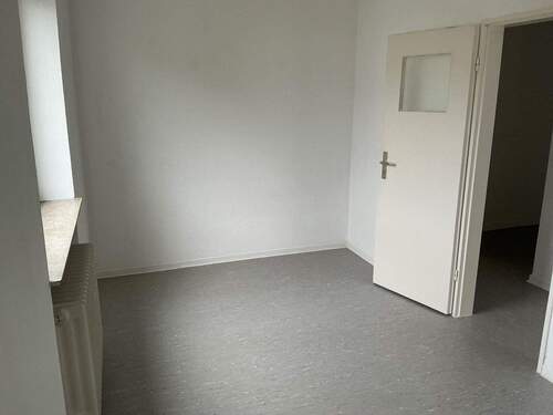 Zimmer 2 mit grauem PVC-Boden und weißen Wänden - 