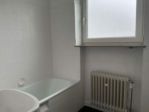 Tageslichtbad mit großem Fenster und Badewanne - 