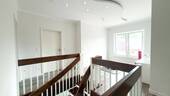 Heller Flur mit Holztreppe - 