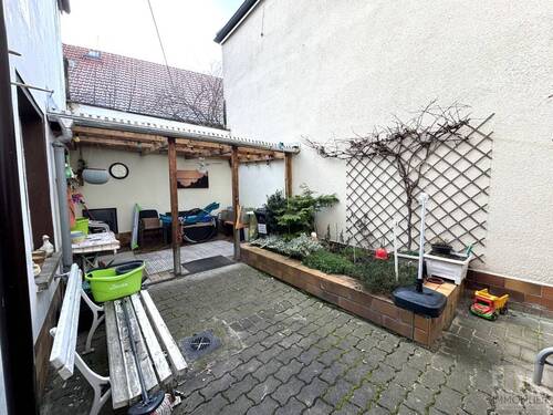 Innenhof mit Terrasse, Hochbeet und rankendem Wein - 