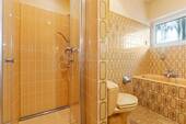 Badezimmer mit Dusche, Badewanne und Fenster - 
