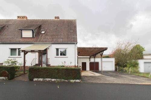 Außenansicht mit Carport und Garage - Charmante Doppelhaushälfte mit hohem Carport, Garage und großem Garten