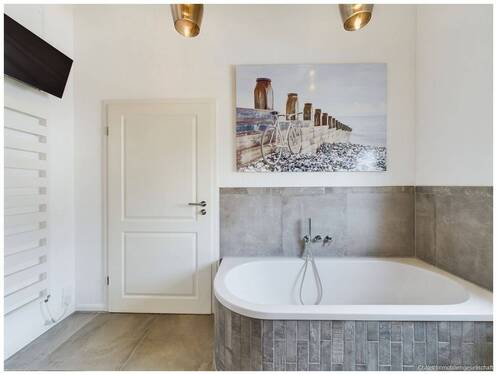 Badezimmer mit Badewanne und Handtuchheizkörper - 