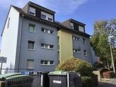 Gebäude Vorderseite des mehrstöckigen Wohnhauses umgeben von Grünanlagen mit Bäumen und Sträuchern - Nachmieter für kleine 3-Zimmerwohnung gesucht!