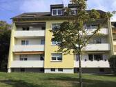 Rückansicht des mehrstöckigen Wohngebäudes mit Balkonen, umgeben von Grünanlagen mit Bäumen und grünen Sträuchern - Etagenwohnung mit 64,80 m&sup2; in Friedrichsdorf zur Miete
