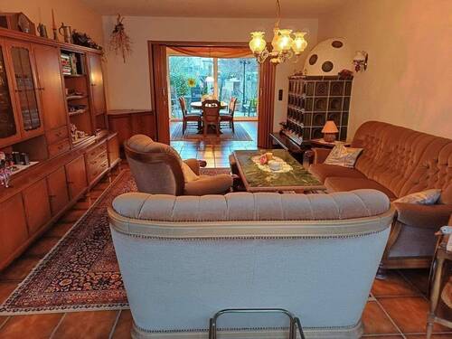 Wohn-Esszimmer mit Kachelofen und Ausgang Freisitz - 