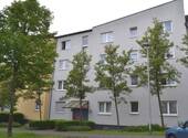 Lindenallee 23, Außenansicht auf den Eingangsbereich eines mehrgeschossigen Wohngebäudes mit heller Fassade und markanter Architektur. - Helle 3-Zimmerwohnung mit Balkon in Baunatal-Baunsberg