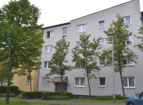 Lindenallee 23, Außenansicht auf den Eingangsbereich eines mehrgeschossigen Wohngebäudes mit heller Fassade und markanter Architektur. - Helle 3-Zimmerwohnung mit Balkon in Baunatal-Baunsberg