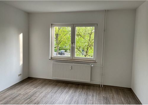 Schlafraum mit Blick auf das Fenster, helle Wände und hellgrauer PVC-Bodenbelag in Holzoptik.PNG - 