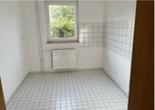 Küche mit Blick in Richtung Fenster, helle Wände, helle Bodenfliesenund heller Fliesenspiegel.PNG - 