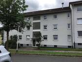Akazienallee 20, Außenansicht auf den Eingangsbereich eines mehrgeschossigen Wohngebäudes mit heller Fassade und Satteldach - Großzügige 4-Zimmerwohnung mit Sonnenbalkon in Baunatal-Baunsberg