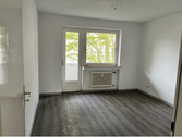 Schlafraum mit Zugang zum Balkon, helle Wände und hellgrauer PVC-Bodenbelag in Holzoptik.PNG - Etagenwohnung mit 109,60 m&sup2; in Baunatal zur Miete