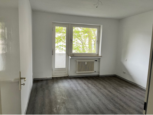Schlafraum mit Zugang zum Balkon, helle Wände und hellgrauer PVC-Bodenbelag in Holzoptik.PNG - Etagenwohnung mit 109,60 m&sup2; in Baunatal zur Miete