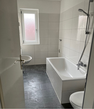 Tageslichtbad mit Wanne, helle Wand- und dunkle Bodenverfliesung.PNG - 