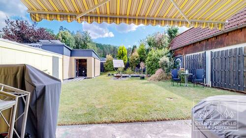 Blick von Terrasse auf Garten und Nebengebäude - 
