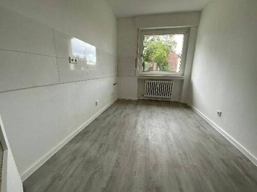 Blick von Diele in Küche mit weißen Fliesenspiegel und weißen Wänden, weißen Fenstern, grauem PVC-Boden.jpg - 