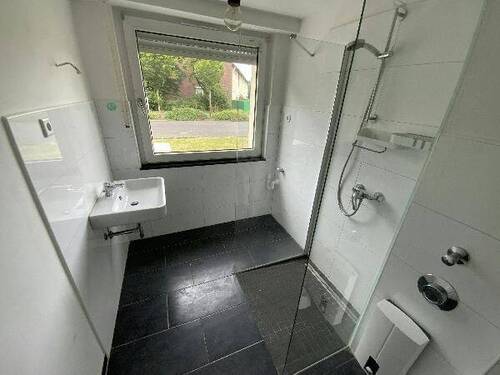 Blick in Bad mit weißen Wandfliesen, weißem Waschbecken, grauen Bodenfliesen, Hänge-WC und Dusche II.jpg - Etagenwohnung mit 77,00 m&sup2; in Meerbusch zur Miete