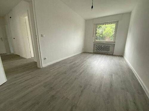 Blick in Kinderzimmer mit grauem PVC-Boden und weißen Wänden mit weißem Fenstern.jpg - 
