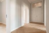 Blick vom Flur auf die Eingangstür. Links befindet sich das Schlafzimmer, links hinten das Badezimmer und rechts das Wohnzimmer. - 