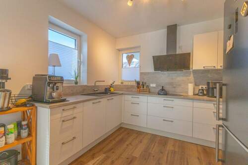 Küche mit Schiebetür zum Wohnzimmer und Zugang zur Terrasse - 