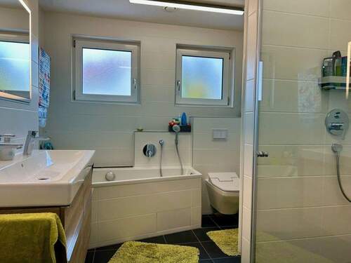 Tageslichtbad mit Badewanne und begehbarer Dusche im OG - 