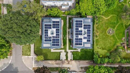 Drohnenaufnahme mit Blick auf das Flachdach und die Wärmepumpen, Solar und PV Anlage - 