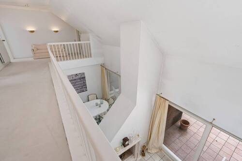 Galerie oberhalb des zentralen Flurbereichs mit Kaminecke und Esstisch. - 