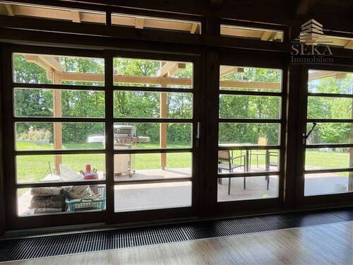 Glasfront Wohnbereich mit Blick in den Garten - 