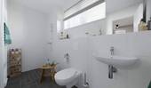 Ein modern gefliestes Badezimmer mit bodengleicher - 