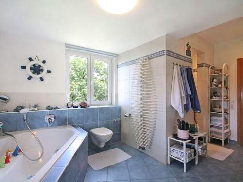 Viel Raum zur Entspannung im Tageslichtbadezimmer mit Eckbadewanne und Duschnische - 