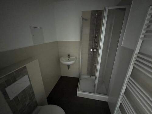 Badezimmer mit Dusche und Handtuchheizkörper - 