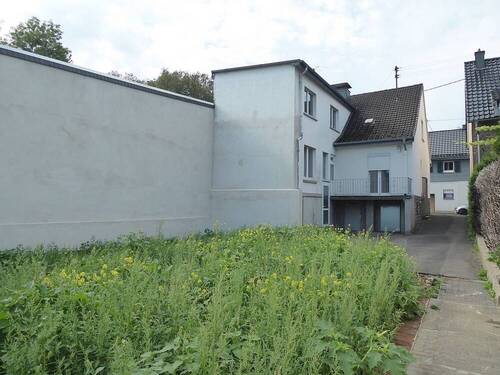 Haus mit Anbau und Gartenfläche - 